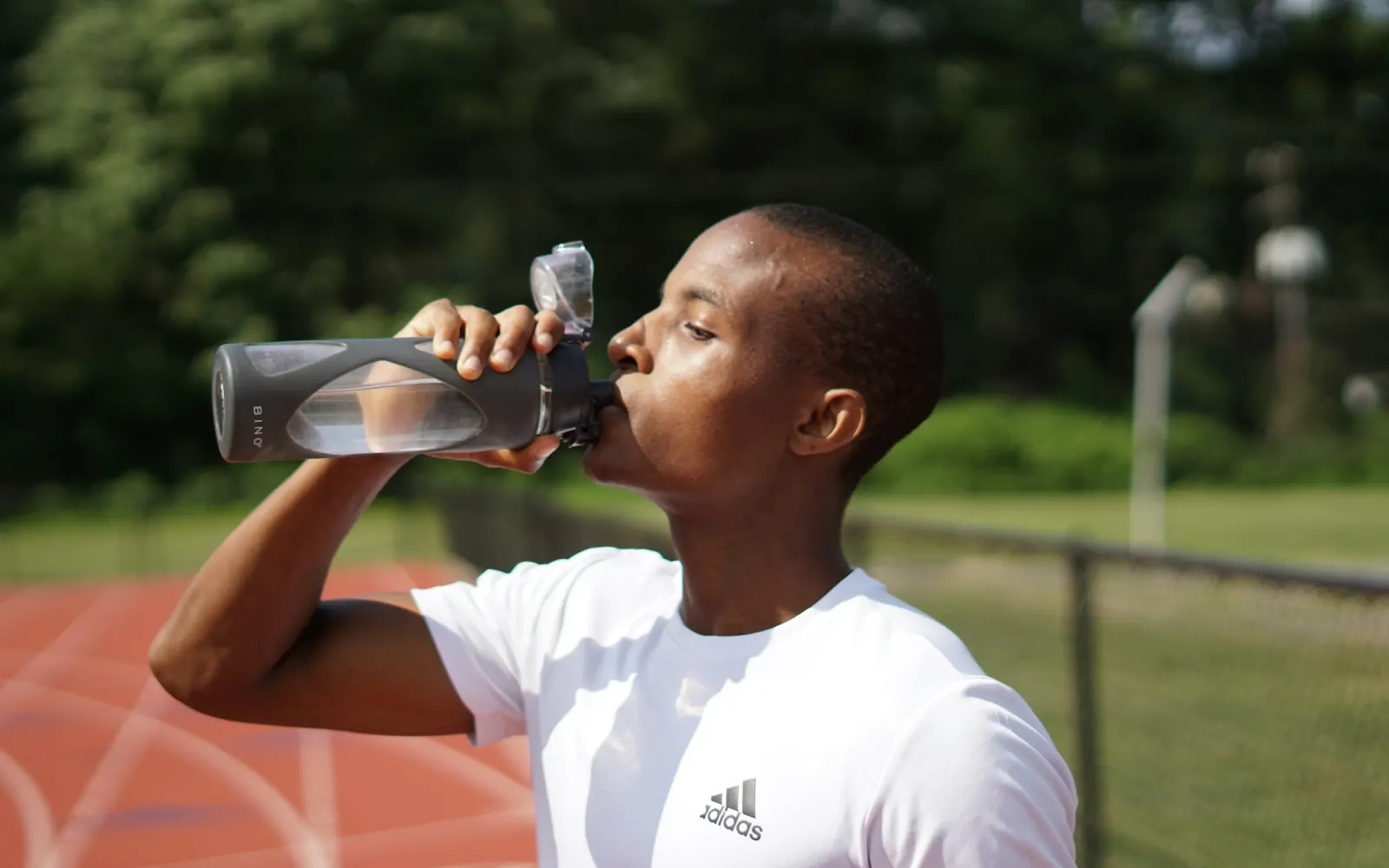 Coureur qui boit à une gourde de sport noire