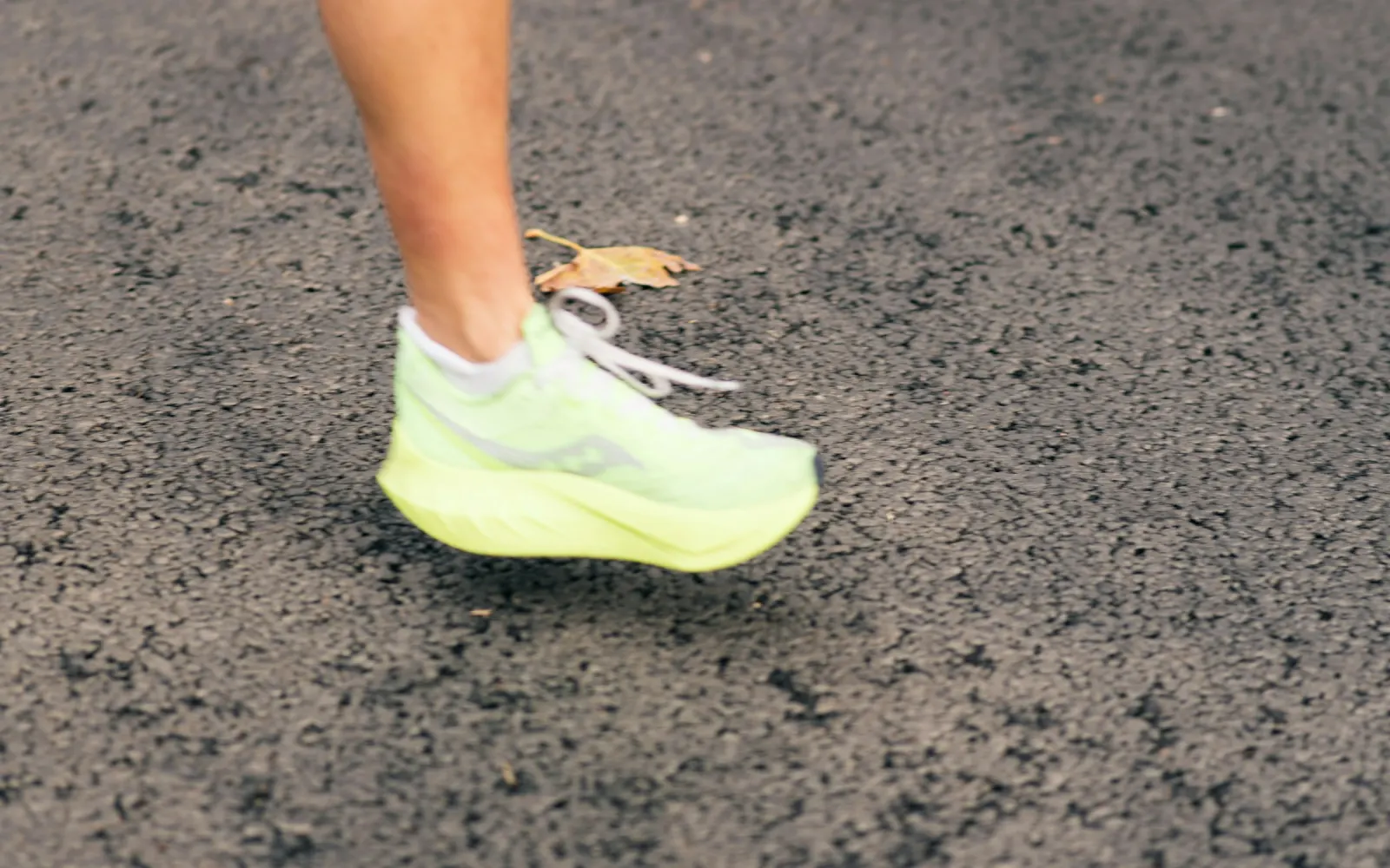 Chaussure de running jaune fluo posée sur un sol sombre